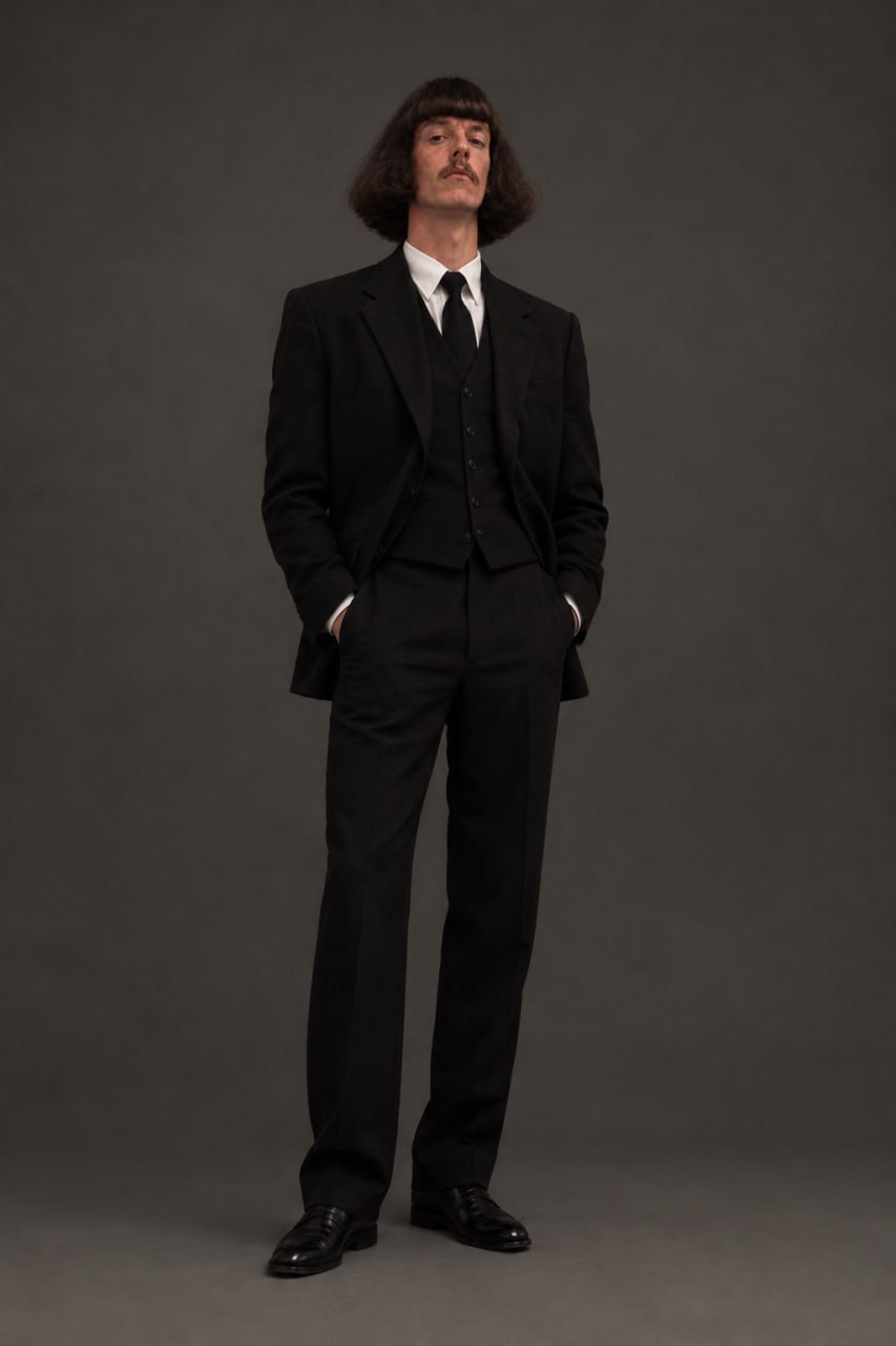 SOL Phil standing in a black suit with his hands in his pockets